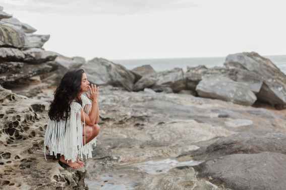 photo of woman sitting on rock